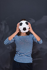 Image showing woman holding a soccer ball in front of chalk drawing board