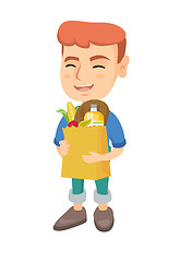 Image showing Boy holding paper shopping bag full of groceries.