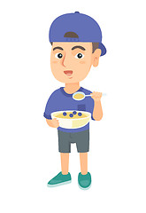 Image showing Happy boy holding a spoon and bowl of porridge.