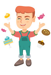 Image showing Happy caucasian boy standing among lots of sweets.