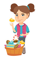 Image showing Girl holding a cupcake and stroking her belly.