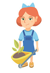 Image showing Girl pushing wheelbarrow with soil and plant.