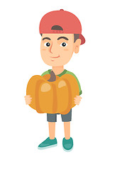 Image showing Caucasian boy standing with a big orange pumpkin.