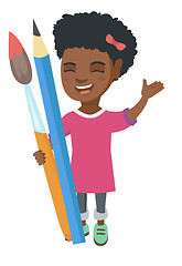 Image showing Smiling girl holding big pencil and paintbrush.