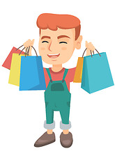 Image showing Happy caucasian boy holding shopping bags.