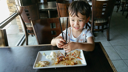 Image showing Cute Young Chinese and Caucasian Boy Learning To Use Chopsticks 