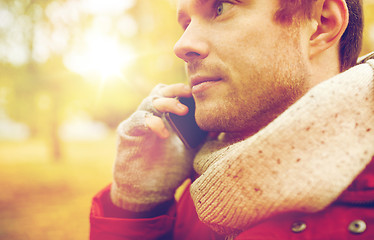 Image showing close up of man with smartphone calling in autumn