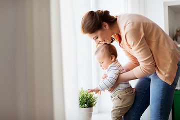 Image showing happy young mother with little baby at home