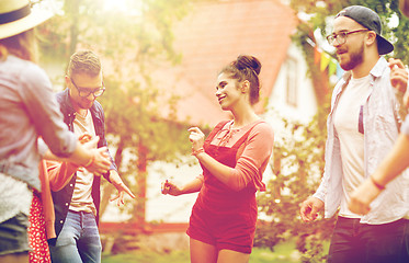 Image showing happy friends dancing at summer party in garden