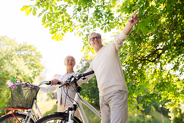 Image showing happy senior couple with bicycles at summer park