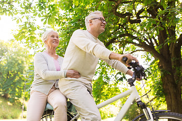 Image showing happy senior couple riding on bicycle at park