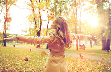 Image showing happy woman having fun with leaves in autumn park