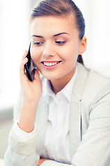 Image showing businesswoman with smartphone in office