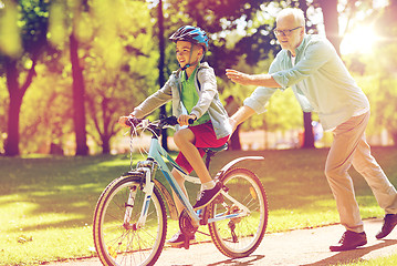 Image showing grandfather and boy with bicycle at summer park