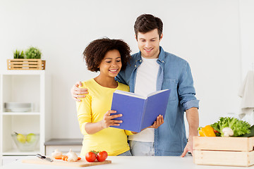 Image showing happy couple with cooking book at home kitchen