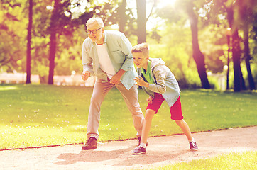 Image showing grandfather and grandson racing at summer park