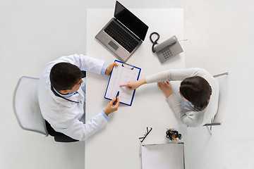 Image showing doctor with cardiogram and patient at hospital