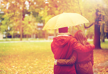 Image showing happy couple with umbrella walking in autumn park