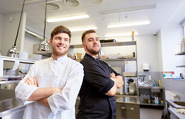 Image showing happy smiling chef and cook at restaurant kitchen