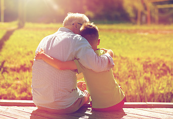 Image showing grandfather and grandson hugging on berth