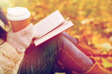 Image showing woman with book drinking coffee in autumn park