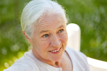 Image showing happy senior woman sitting on bench at summer park