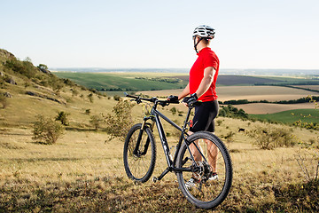 Image showing portrait of young cyclist with his mountain bike bicycle outdoors