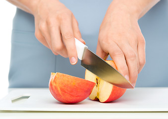 Image showing Cook is chopping apple