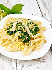 Image showing Pasta penne with spinach and cedar nuts on light board