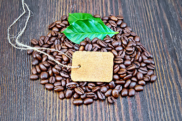 Image showing Coffee black grain with tag and leaf on board