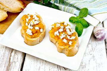 Image showing Bruschetta with pumpkin and feta in plate on board