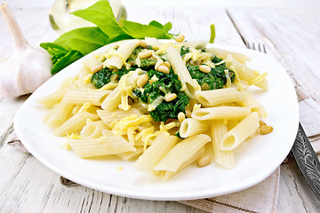 Image showing Pasta penne with spinach and nuts on light board
