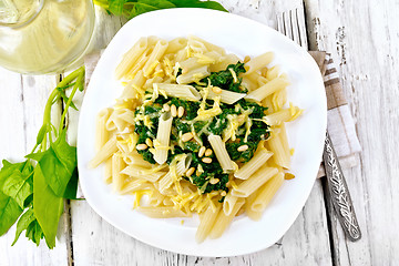 Image showing Pasta penne with spinach and nuts on board top