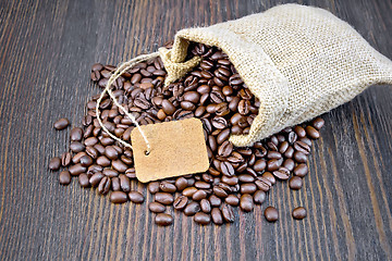 Image showing Coffee black grain with tag in bag on dark board