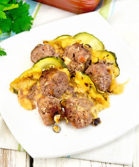 Image showing Meatballs with zucchini and cheese in plate on light board