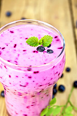 Image showing Milkshake with blueberries in glass on table