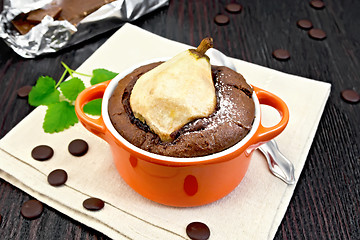 Image showing Cake with chocolate and pear in red bowl on towel