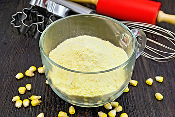 Image showing Flour corn in glass cup on dark board