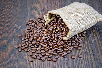Image showing Coffee black grain in bag on dark board