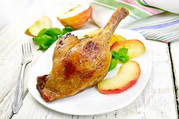 Image showing Duck leg with apple on board