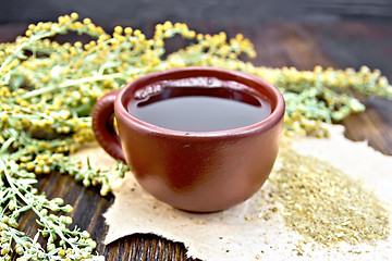 Image showing Tea with wormwood in brown cup on table