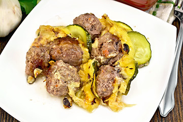 Image showing Meatballs with zucchini and cheese in plate on dark board