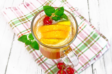 Image showing Lemonade with cherry and orange in wineglass on light board