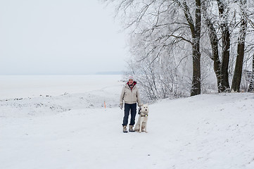 Image showing Woman walking with a dog in winter