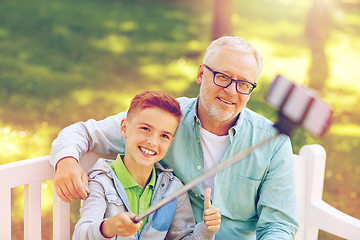 Image showing old man and boy taking selfie by smartphone