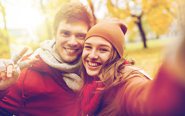 Image showing happy young couple taking selfie in autumn park