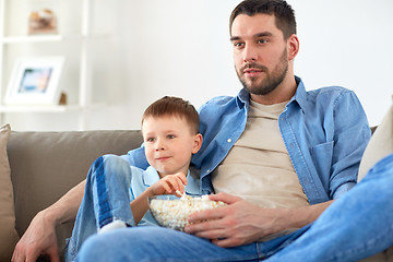 Image showing father and son with popcorn watching tv at home