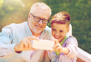 Image showing old man and boy taking selfie by smartphone