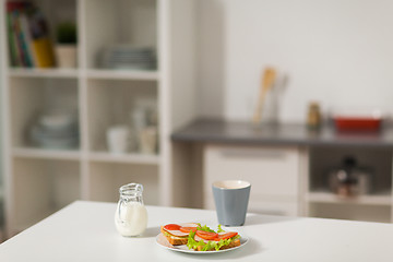 Image showing sandwiches with coffee and cream at home kitchen