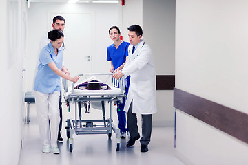 Image showing medics with woman on hospital gurney at emergency